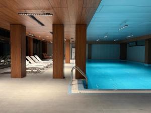 a large swimming pool in a building with wooden ceilings at Afrosiyob in Stantsiya Kyzyl-Tukumachi