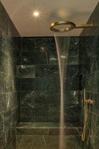 a shower in a bathroom with green tiles at Tifakara by the Waterfall in Fortuna