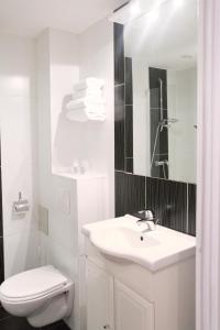 Hôtel Des Vosges في La Celle-sous-Gouzon: حمام أبيض مع حوض ومرحاض