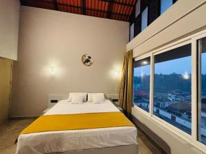 a bedroom with a bed and a large window at Hira Homestay Wayanad, Family-Friendly Stay Near Banasura Dam in Pinangode