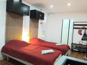due letti con lenzuola rosse in una stanza di Appartement 4 ou 2 Parking Wifi Terrasse cosy a Condé-sur-Sarthe