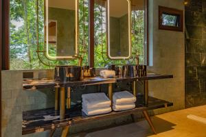 a bathroom with mirrors and sinks and towels at Tifakara by the Waterfall in Fortuna