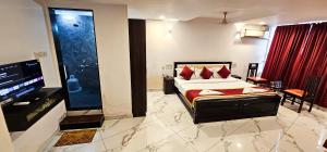 a hotel room with a bed and a television at SAADHANA COMFORTS LODGE in Udupi