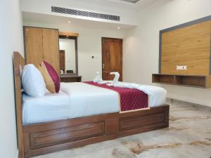 a bedroom with a large bed with swans on it at VGN Convention Centre in Vāniyambādi