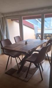a wooden table and chairs in a room with a window at Kleine Strandperle in Fehmarn
