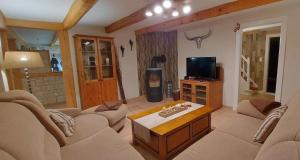 a living room with a couch and a tv at Große Strandperle in Fehmarn +4 photos