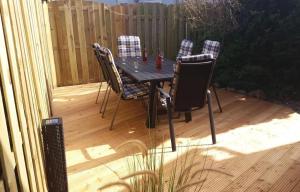a black table and chairs on a wooden deck at Große Strandperle in Fehmarn