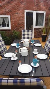 a wooden table with plates and bowls on it at Große Strandperle in Fehmarn