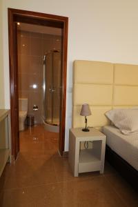 a bedroom with a bed and a bathroom with a shower at Vista Mar in Tarrafal