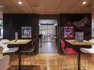 um restaurante com duas mesas e cadeiras em uma sala em ibis budget Montpellier Sud Près d'Arènes em Montpellier