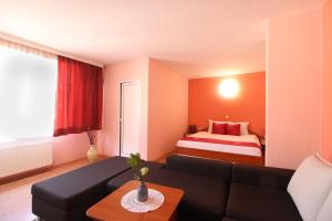 a living room with a couch and a bed at Семеен Хотел Флора in Zlatograd