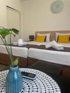 a room with two beds and a vase on a table at Семеен Хотел Флора in Zlatograd