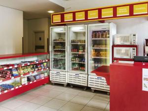 a store aisle with refrigerators in a grocery store at ibis budget Rio de Janeiro Centro in Rio de Janeiro +55 photos