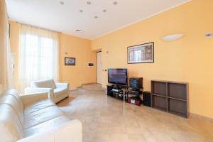 een woonkamer met een bank en een tv bij Hostdomus - Il Maestrale Apartment in Alassio