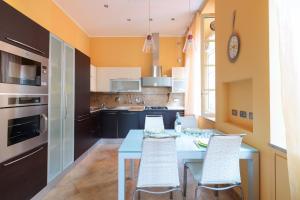een keuken met een blauwe tafel en stoelen bij Hostdomus - Il Maestrale Apartment in Alassio +25 foto's