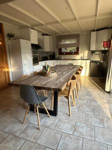 Una gran cocina con una mesa y sillas de madera. en Chalet 't Vraagteken, en Durbuy