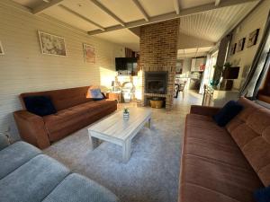 Una sala de estar con dos sofás y una chimenea. en Chalet 't Vraagteken, en Durbuy