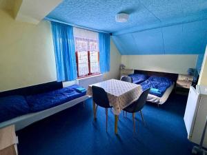 a room with two beds and a table and chairs at Privat Pohoda in Paseky nad Jizerou