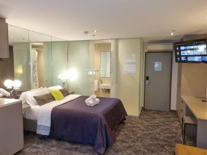 a hotel room with a bed and a television at Melbourne ViVo in Melbourne