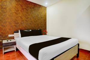 Un dormitorio con una cama y una pared. en Palette by CheckIn Igatpuri Formerly Bodh Valley Resort, en Igatpuri