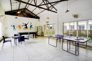 una habitación con mesas de ping pong y sillas. en Palette by CheckIn Igatpuri Formerly Bodh Valley Resort, en Igatpuri