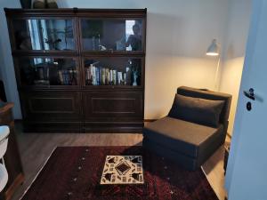 a living room with a chair and a book shelf at Huoneisto järvinäkymin, Palokka in Jyväskylä