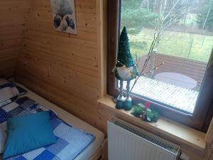 a room with a window with a christmas tree on it at Domki Bursztyn in Święta Katarzyna