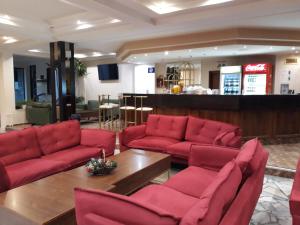 Un vestíbulo con sofás rojos y una mesa de café. en Finlandia Hotel, en Pamporovo