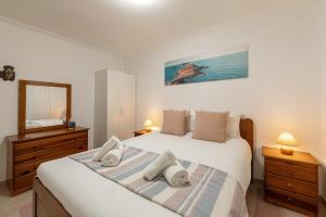 a bedroom with a large bed and a mirror at Ocean Breeze Baleal in Ferrel