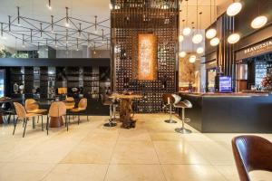 ein Restaurant mit Tischen und Stühlen und eine Bar in der Unterkunft Rivieira 2 Suítes e Jacuzzi by Achei Camboriu in Cabeçudas