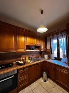 a kitchen with wooden cabinets and a sink and a window at MetsoVillas στο κέντρο του Μετσόβου in Metsovo +50 photos