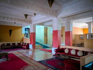 ein Wohnzimmer mit roten Stühlen und einer rot-gelben Wand in der Unterkunft Hotel Taddart in Midelt + 110 Fotos