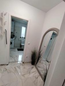 a bathroom with a marble floor and a mirror at Apartman Novska Noemi in Novska