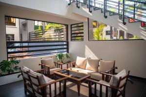 a living room with a couch and chairs and windows at The Meru House in Nkubu