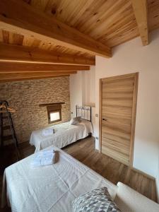 La Campanilla في Los Corrales: غرفة نوم بها سريرين وجدار من الطوب