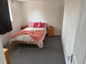 een slaapkamer met een bed met roze kussens erop bij The Lantern in Bristol