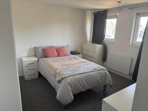 een kleine slaapkamer met een bed met roze kussens bij The Lantern in Bristol