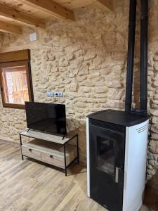 La Campanilla في Los Corrales: غرفة معيشة مع مدفأة وتلفزيون
