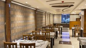 a dining room with white tables and chairs at Rojina Hotel in Amman