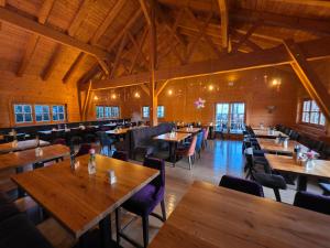 Johns Wirtshaus في Saarwellingen: مطعم فارغ مع طاولات وكراسي خشبية