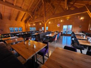 Johns Wirtshaus في Saarwellingen: مطعم فارغ مع طاولات وكراسي خشبية