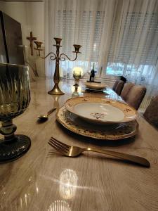 a dining room table with a plate and a fork and knife at Apartman Novska Noemi in Novska +1 photo