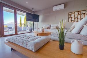 een woonkamer met een grote bank en een tv bij Marnos Luxury Villas in Kamilari