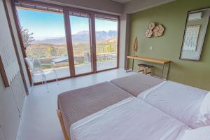 een slaapkamer met een groot bed en een groot raam bij Marnos Luxury Villas in Kamilari +175 foto's