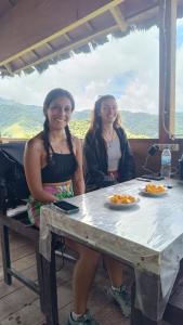 Watuburu Cottage & Restaurant في كيليموتو: كانتا جالستين على طاولة مع أطباق من الطعام +6 صور