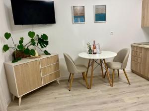 a living room with a table and chairs and a tv at Danube12 in Šamorín