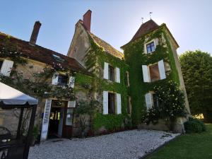 an old building covered in ivy on a street at La Longère du Sallay in Saincaize-Meauce