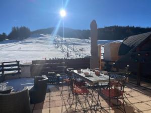 a table and chairs on a balcony with a ski slope at Le Logis de Bamby in Ancelle