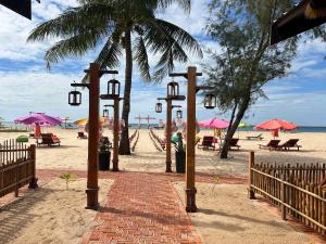 um caminho de tijolos em uma praia com guarda-sóis e cadeiras em Bien Ngot Resort Phu Quoc em Duong Dong mais 34 fotografias