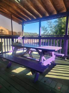 una mesa de picnic en la cubierta de una cabaña en Bellus-Rose Pension Gyeongju, en Gyeongju